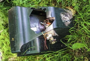 Çimenlerde eski retro tv. Gezegendeki çöpler. Doğal çevrenin kirlenmesi. Unutulmuş, cihazı, yerdışı kurtarın. Birisi sahada televizyonunu unutmuş.