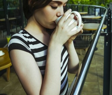 Sakin sabah genç kız lüks otel balkonunda içecek manzarası zevk kahvaltı kahve içme rahatlatıcı, yaz seyahat tatilleri. Evde yaşam.