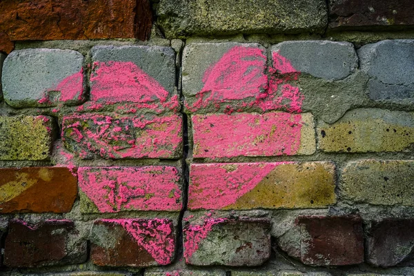 Broken brick wall with chalk drawing of red heart. divorce, treachery conce...