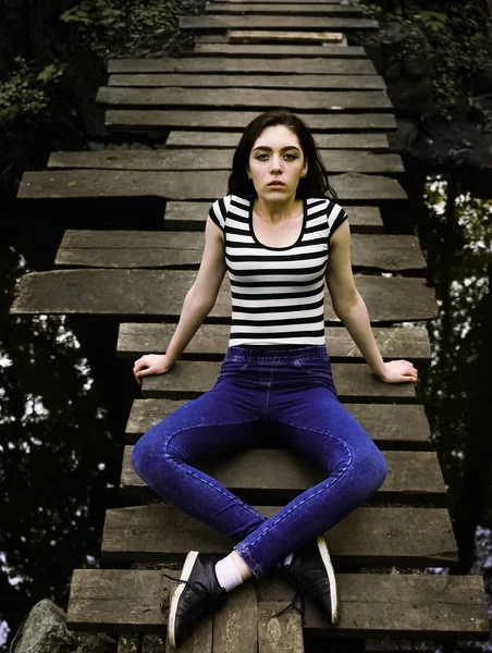 Młoda Kobieta Siedzi Zrelaksowany Drewnianym Moście Nad Rzeką — Zdjęcie stockowe