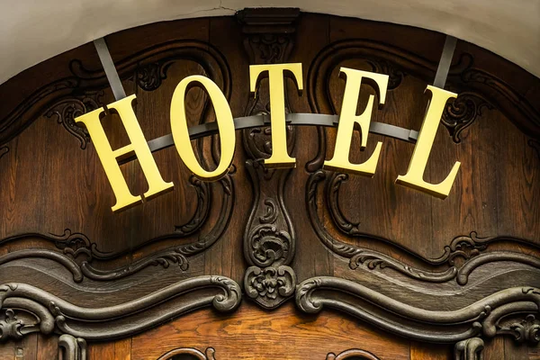 Vackert hotellskylt-metallisk skylt bredvid entré trä d — Stockfoto