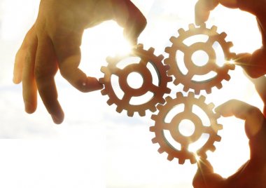 Metal dişlileri tutan eller. takım çalışması fikri