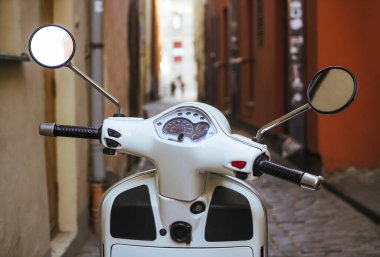 Riga, Letonya - 30 Nisan 2019: Vespa beyaz Scooter eski dar Avrupa caddesinde.