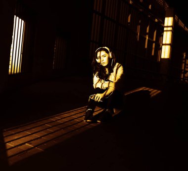 Neşeyle dinleniyor. Güzel genç kadın müzik dinliyor ve otoparkta yerde oturuyor. güneşli ışık ve yüzünde gölgeler