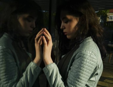 Kentsel bir ortamda deri ceket li genç moda kız portresi ve cam yansıması