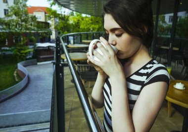 Sakin sabah genç kız lüks otel balkonunda içecek manzarası zevk kahvaltı kahve içme rahatlatıcı, yaz seyahat tatilleri. Evde yaşam.