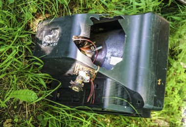 Çimenlerde eski retro tv. Gezegendeki çöpler. Doğal çevrenin kirlenmesi. Unutulmuş, cihazı, yerdışı kurtarın. Birisi sahada televizyonunu unutmuş.