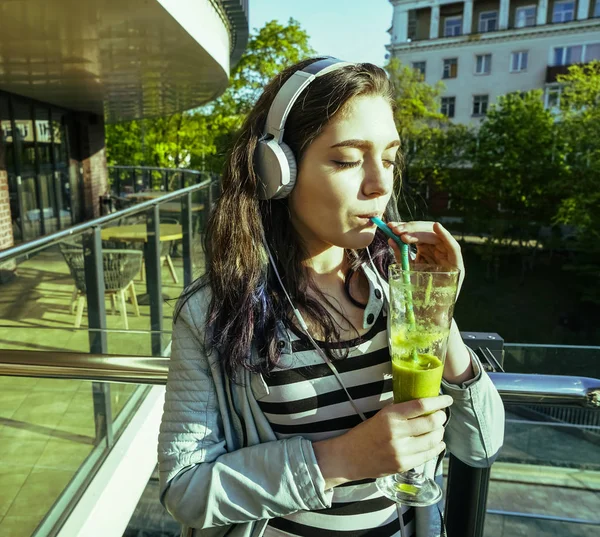 Young pretty woman drinking  smoothie  in glass.beautiful girl enjoying a smoothie drink