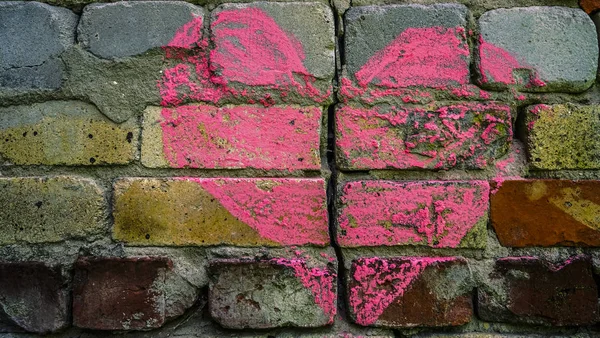 Broken brick wall with chalk drawing of red  heart. divorce, treachery concept