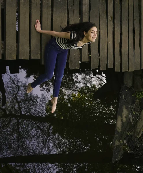 Mujer Joven Sentada Relajada Puente Madera Sobre Río —  Fotos de Stock