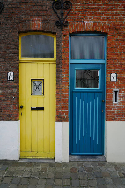beautiful  and colorful entrance of an old house with a two - yellow and blue wooden doors.