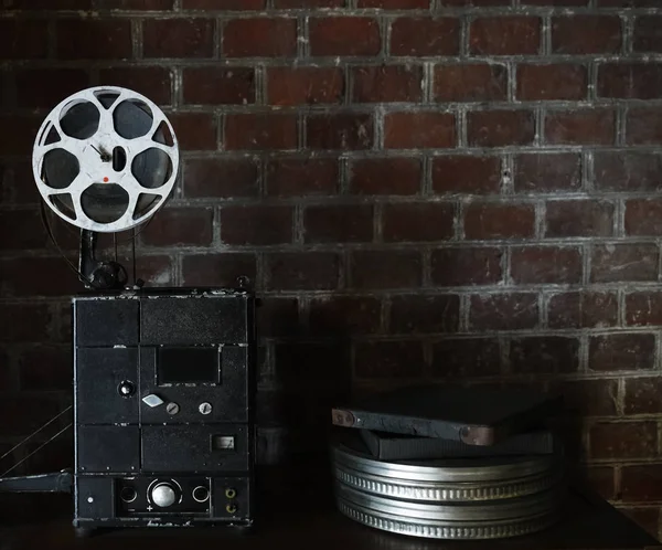 photo of an old movie projector on brick wall background. Old style movie projector, still-life, close-up.