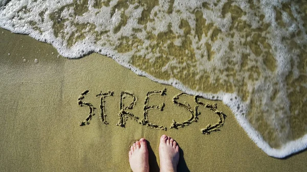 ターコイズブルーの水でビーチのストレスに署名します ストレスが洗い流される 裸足の男 トップビュー — ストック写真