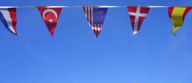  mavi gökyüzü arka plan karşı üçgen Hollandaca, Türk, Amerikan, Norveç ve İspanyol bayrakları. Dünya bayrakları seti