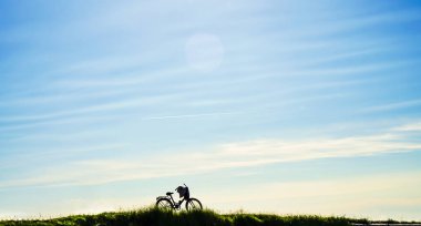 bulutlar ile mavi günbatımı gökyüzünde bir bisiklet silueti. cennet arka planda bisiklet. hiçbir kişi. 
