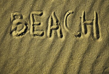 Kumdaki yazıt - plaj. Plaj kelimesi kuma elle yazılır. Plaj sezonu. Kartpostal. 