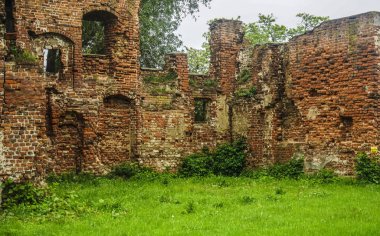 iç, yıkılmış duvarlar ve avlu, eski bir ortaçağ kırmızı tuğla binanın kalıntıları çim ile büyümüş