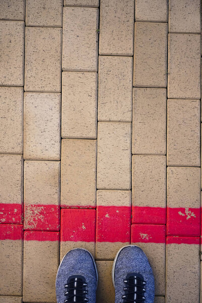 Blue sporty shoes standing on red  line. Crossing the limit
