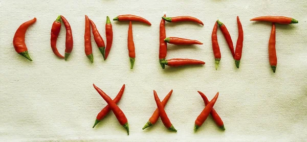 content xxx written from red hot pepper letters isolated on white background