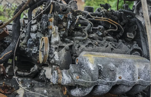 Burnt out car engine interior.old rusty car engine after a fire, burnt and melted engine parts, close-up