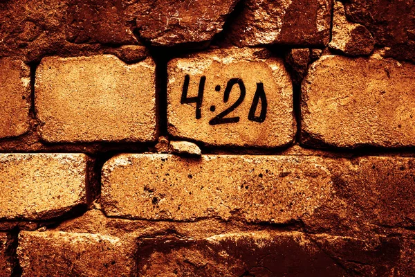 time of 4-20 pm. inscription on brick wall.special time accociated with smoking marijuana. A universal ritual were everyone sparks up their joint, blunt, pipe, or bong at exactally 4:20 pm