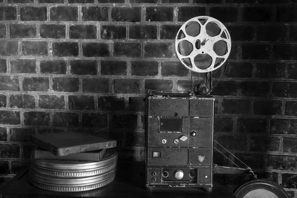 photo of an old movie projector on brick wall background. Old style movie projector, still-life, close-up.