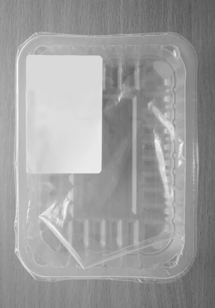 empty  plastic  container. Plastic food package isolated on wooden background. blank - white label.  empty copy space for inscription.