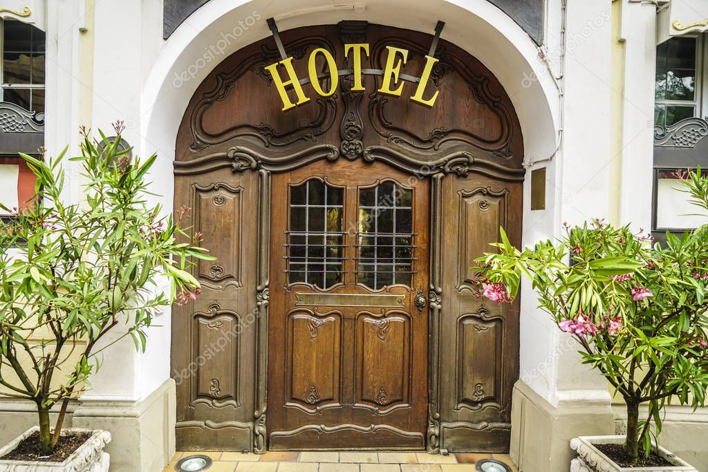 Beautiful HOTEL  sign - metallic plate next to entrance wooden door 