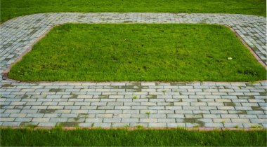 Taş blok yeşil çim arka plan ile parkta yürüyüş yolu. perspektif olarak parkta kare Pathway. Taş kaldırım dokusu.