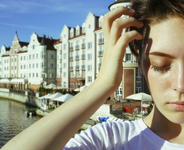 Portre büyüleyici kısa saçlı esmer kız beyaz bir t-shirt, gözleri kapalı, güneş ışığı zevk