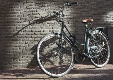 siyah klasik yol bisikleti metin veya kopyalamak için gölgeler ve boşluk ile güneşte gri tuğla duvara yaslanmış