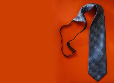 Kırmızı kağıt arka plan üzerinde izole mor desenli zarif koyu mavi kravat