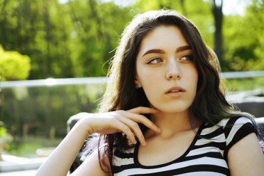 Parlayan güneş üzerinde çizgili t-shirt güzel bir esmer saçlı kız portresi kadar yakın. 