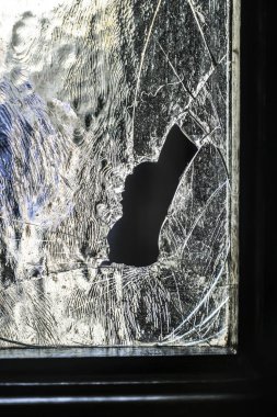 Terk edilmiş bir binanın eski camı kırıldı. Büyük cam çatlakları ile taraflı bir binada harap bir pencere