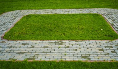Taş blok yeşil çim arka plan ile parkta yürüyüş yolu. perspektif olarak parkta kare Pathway. Taş kaldırım dokusu.