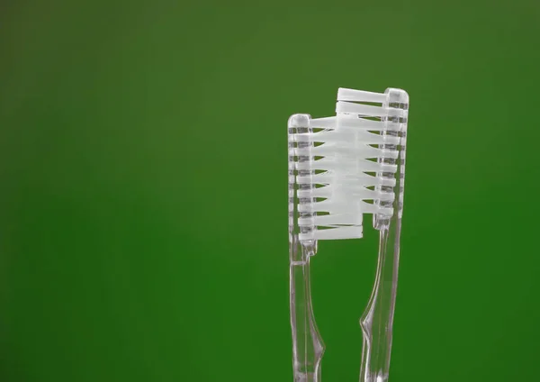 緑色の背景に2本の透明な歯ブラシ デートとキスカップルの概念 セックスのアイデア — ストック写真