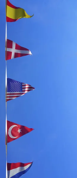 Trojúhelníková Holandská Turecká Americká Norská Španělská Vlajka Proti Modrému Nebi — Stock fotografie