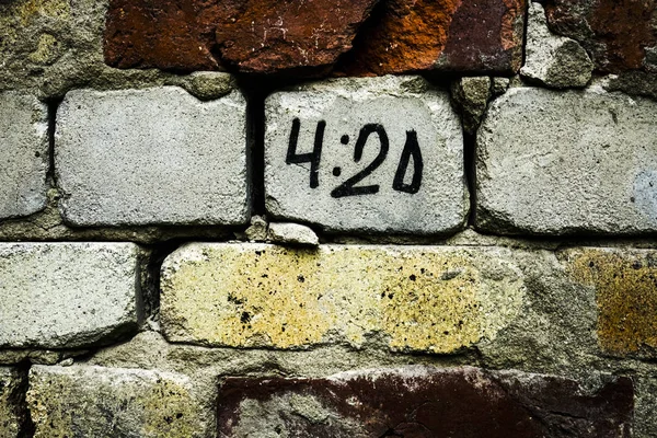 time of 4-20 pm. inscription on brick wall.special time accociated with smoking marijuana. A universal ritual were everyone sparks up their joint, blunt, pipe, or bong at exactally 4:20 pm