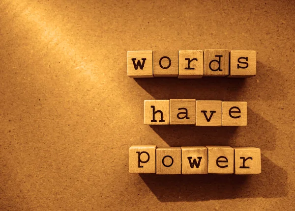words  Words Have Power written in  wooden alphabet letters isolated on an craft paper - carton background with empty copy space. ray of sunshine