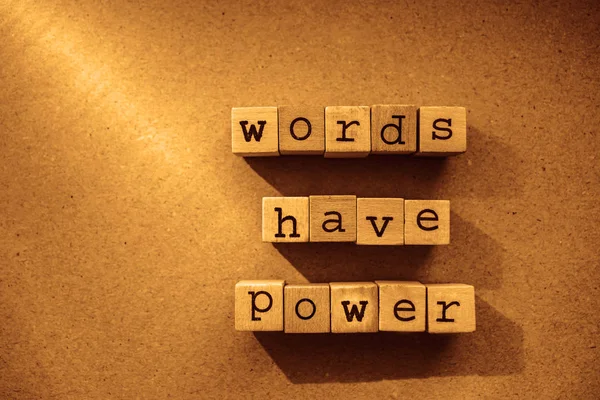 words  Words Have Power written in  wooden alphabet letters isolated on an craft paper - carton background with empty copy space. ray of sunshine