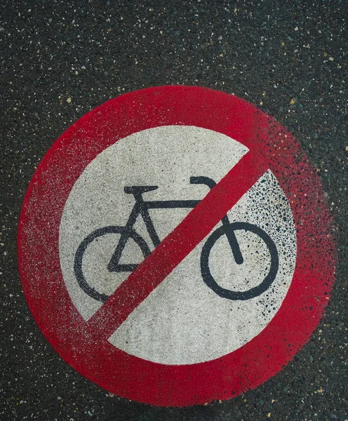 vertical photo of urban signal painted on the asphalt of road forbidden to ride bicycles that way.