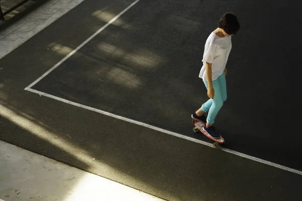 portrait of teen girl with long skate board standing on skate park background