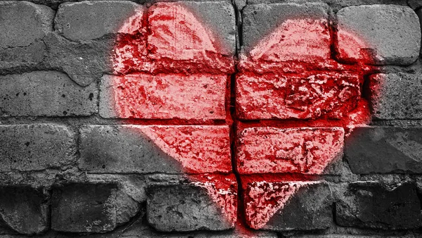 Broken brick wall with chalk drawing of red  heart. divorce, treachery concept