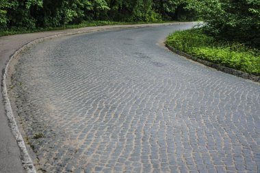 Dairesel desenli arnavut kaldırım taşları ile rögar kapağı, perspektif çekim. perspektifte boş yol. 