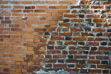 Eski bir sanayi binasının tuğla duvarının detayları. Sol kısmı eski tuğlaoluşur ve ayakta, yeni kırmızı tuğla ile orta duvar yenilenmiştir