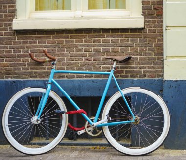 kahverengi ve beyaz duvar arka plan üzerinde sportif eski tarz mavi bisiklet. mavi ve kahverengi bisiklet park dış. kırmızı tuğla duvar arka plan