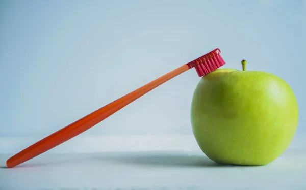 Manzana Verde Con Cepillo Dientes Rojo Aislado Sobre Fondo Azul —  Fotos de Stock