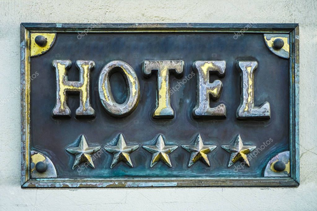 Golden Board or signboard for a 5 five star hotel. 5 star hotel signage board. Wall of a building with a sign for a hotel with star declaration