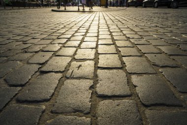 yürümek için arnavut kaldırım Stone arka plan. Granit bloklardan yapılmış bir duvar ile güneş ışığında Arnavut kaldırımlı sokak