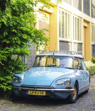 Leiden, Hollanda - 31 Temmuz 2019: kırmızı bisiklet ve mavi vintage mavi Citroen Ds araba sokakta Hollandalı evin yakınında duran. 